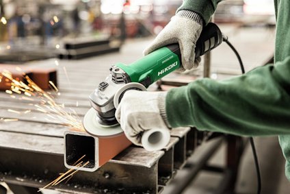 En person använder en grön HiKOKI vinkelslip för att kapa en metallprofil. Gnistor flyger från skärningen.