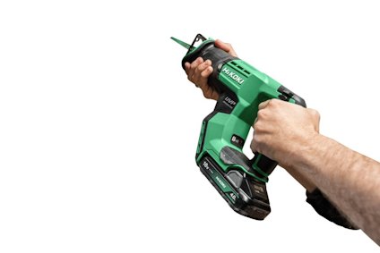 Person som håller i en grön och svart elektrisk skruvdragare med borrskäret pekande framåt.