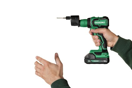 Person som håller en grön och svart HiKOKI borrmaskin med en borr installerad.