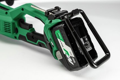 Grön batteridriven sticksåg med svart handtag, synlig batteridel samt knappar och etiketter.