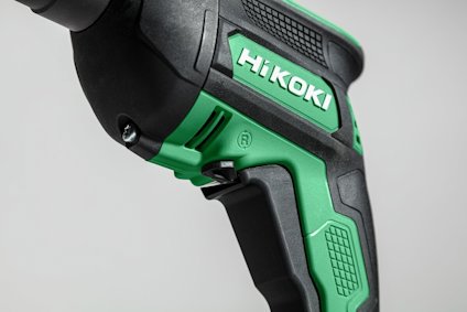 Grön och svart Hikoki borrmaskin, delvis synlig med fokuserad bild på handtaget och märkesnamnet.