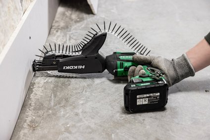 Elektrisk skruvdragare används för att fästa en gipsskiva mot en vägg.