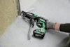 Person använder en HiKoki skruvdragare med automatisk skruvmatning för att montera en gipsskiva.