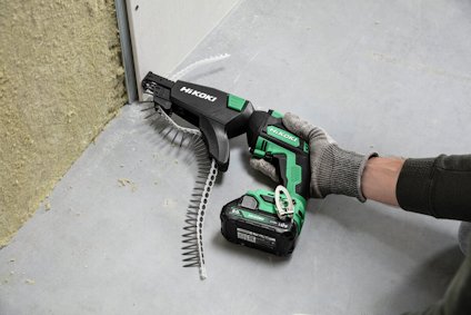 Person använder en HiKoki skruvdragare med automatisk skruvmatning för att montera en gipsskiva.