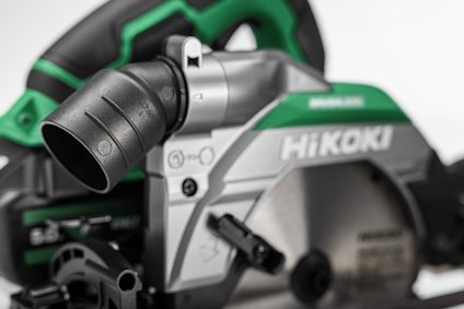 Cirkelsåg med ett grönt och svart handtag, märkt "HiKOKI", med ett fastsatt dammutsug.
