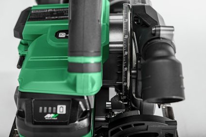 Grön och svart elektrisk handhyvel med inställningsratt och djupguide i närbild.