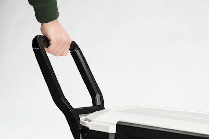 Hand som håller i ett svart handtag på en vit låda.