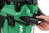 Hand justerar en svart ventil på en grön Hilti-maskin med företagets logotyp synlig.