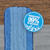 Blå mopp med texten "REMOVES 99% OF BACTERIA" på en trägolvbakgrund.