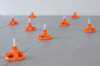 Orange nivåjusterare på gråa kakelplattor.