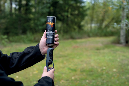 En person håller i fyrverkeritändaren "PIEXON Guardian Angel II" med vegetation i bakgrunden.