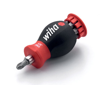 Skruvmejsel med rött och svart handtag, märkt "wiha" och "1/4" 3801", med flera bits i ett integrerat magasin.