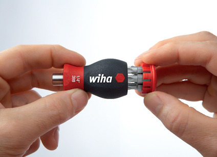 En hand håller ett svart och rött verktyg från "wiha", med flera utbytbara bits synliga.