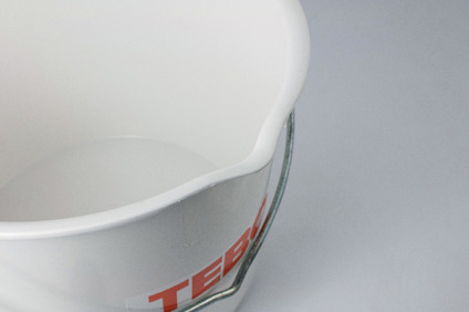 Vit plastspann med tryckta, delvist synliga röda bokstäver.