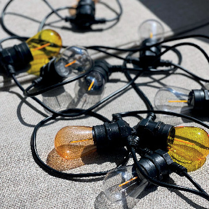 Liggande glödlampor med svart sladd, några i transparent och andra i guldfärgat glas.