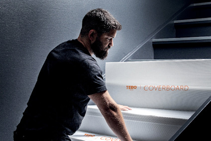 En person monterar vita skyddspaneler på en trappa, med texten "TEBO COVERBOARD" synlig på en panel.