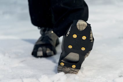 Skor med halkskydd och dubbar på snö.