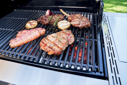 Grill med kött och lök skivas på het glödbädd utomhus.