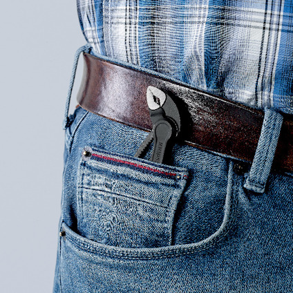 Person med rutiga skjorta och jeans med tång i bakfickan.