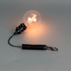 Glödande glödlampa fäst vid en svart handtagsliknande enhet med en karbinhake.